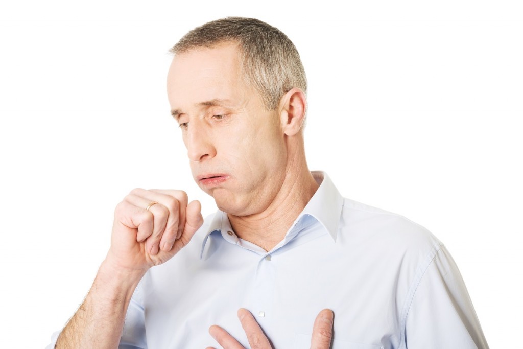 Mature man coughing because of flu.