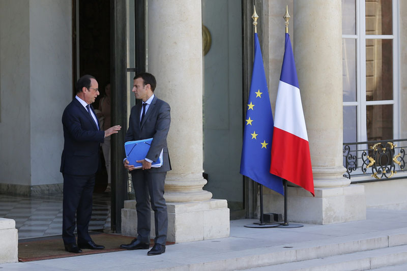 File picture shows French President Francois Hollande (L) as he escorts French Economy Minister Emmanuel Macron while leaving the Elysee Palace following the weekly cabinet meeting, in Paris, France, July 31, 2015. REUTERS/Stephane Mahe/FileCODE: X02520