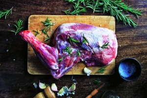 Still life of lambs leg and herbs