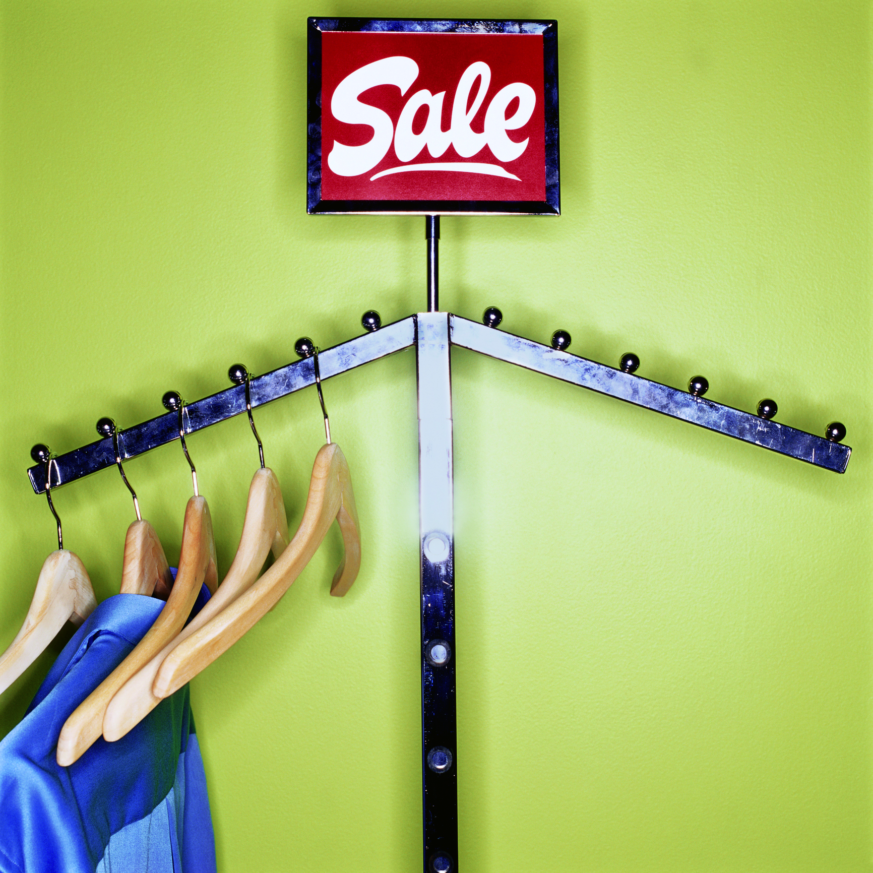 Clothes and wooden hangers hanging on sale rack, close-up