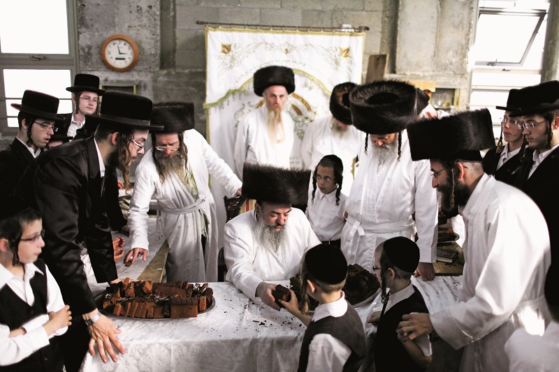 epa03409752 An ultra orthodox Jewish Rabbi from Lelov (Hasidic dynasty) distributes cakes before ultra orthodox men and boys perform the traditional Malkot ceremony at the city of Beit Shemesh, Israel, 25 September 2012, a few hours before the start of Yom Kippur, the most solemn day in the Jewish calendar. Yom Kippur is a 25-hour period of fasting, intense reflection and prayers where the central theme is the Day of Atonement that begins on 25 September after sunset. EPA/ABIR SULTAN