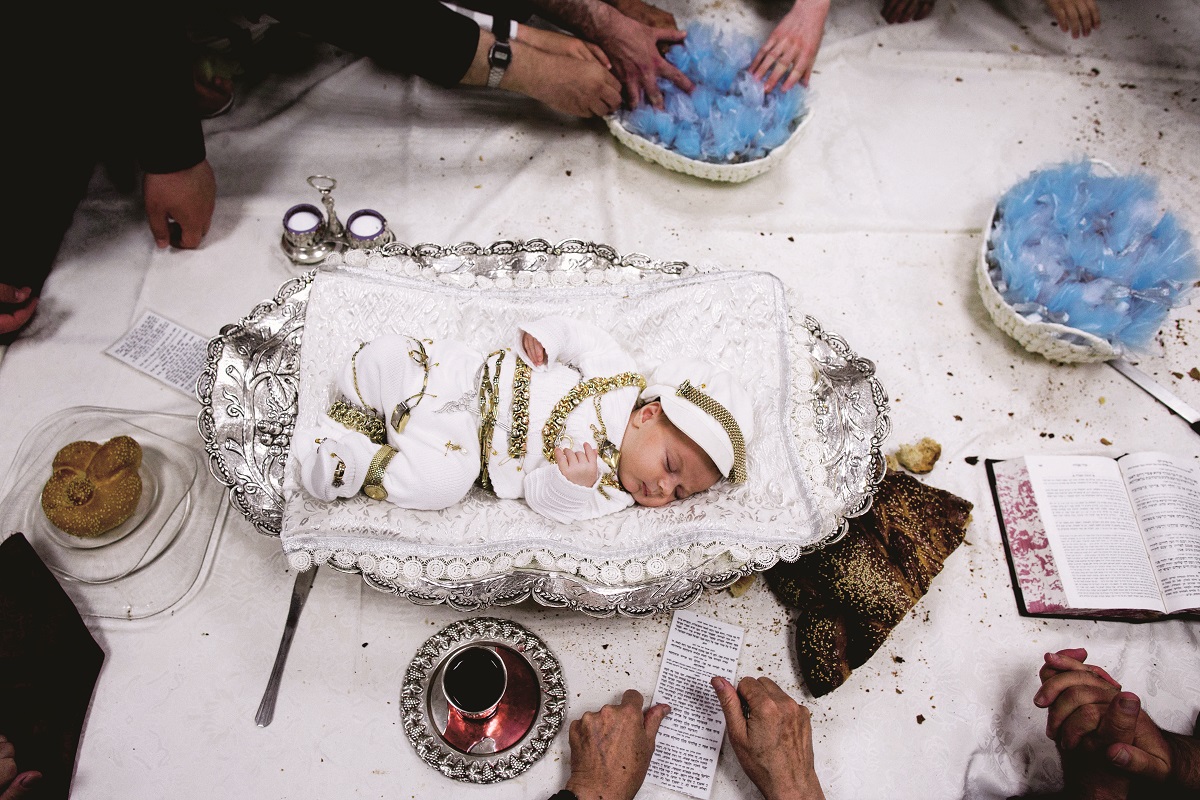 epaselect epa05518195 Ultra Orthodox Jews gather around a new born baby in a silver bowl during the pidyon haben (redemption of the first born son) ritual of the great-grandson of Lelov hasidic dynasty in Jerusalem, Israel, 01 September 2016. Pidyon haben is an ancient Jewish custom in Judaism whereby a Jewish firstborn son is redeemed by use of silver coins from his birth-state of sanctity at the age of 30 days. EPA/ABIR SULTAN