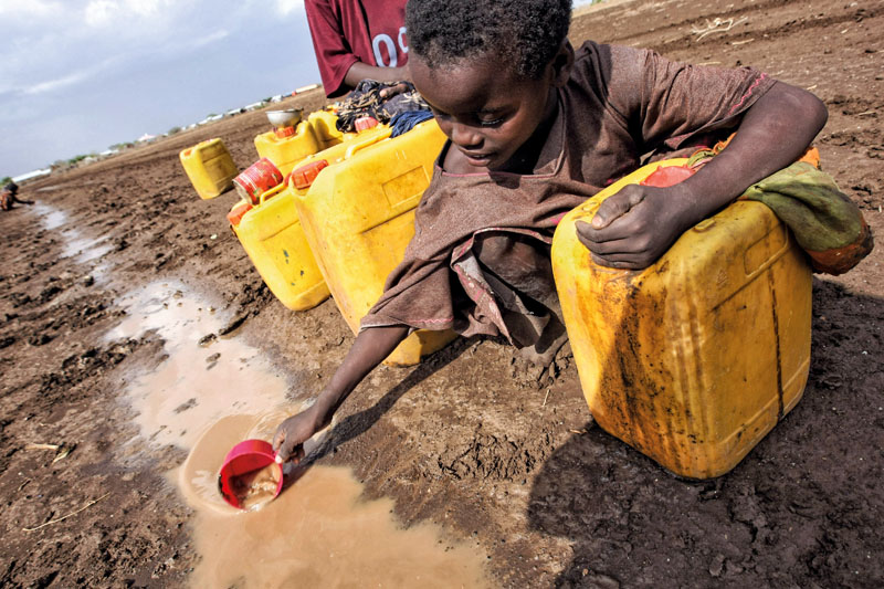 A child collects water from a puddle after a rainstorm near the Torotoro village, 125 km southwest from Mogadishu, Somalia, on March 27, 2009. According to local news sources at least 12 people have died following an outbreak of acute watery diarrhea (AWD) in villages around the regional capital of Jowhar. A local government official said most water points in the area had dried up or were almost dry, "They are desperate and unfortunately, resorting to desperate measures". AFP PHOTO / MOHAMED DAHIR (Photo credit should read MOHAMED DAHIR/AFP/Getty Images)