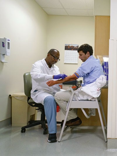 -- PHOTO MOVED IN ADVANCE AND NOT FOR USE - ONLINE OR IN PRINT - BEFORE FEB. 5, 2017. -- Dr. David Fajgenbaum, left, and his patient Gary Gravina who both have Castleman disease, have blood drawn at the Abramson Cancer Center of the University of Pennsylvania. in Philadelphia, July 5, 2016. Fajgenbaum has gone from being a patient on the brink of death five different times, whose illness stumped specialist after specialist, to one of the leading researchers in his field. (Nicole Bengiveno/New York Times)