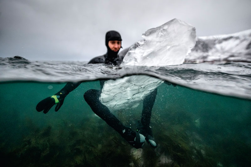 TOPSHOT - Swedish surfer Pontus Hallin waits for waves while sitting on his surfboard made of ice at the Delp surfing spot, near Straumnes, in the Lofoten Islands, over the Arctic Circle on February 18, 2019. - Images can be found on www.afpforum.com with the slug : Surfing-Lofoten-Ice board-Photo essay (Photo by Olivier MORIN / AFP) (Photo credit should read OLIVIER MORIN/AFP/Getty Images)